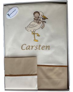 Baby sengetøj med stork bærende en baby og babys navn. Råhvidt og nougatfarvet